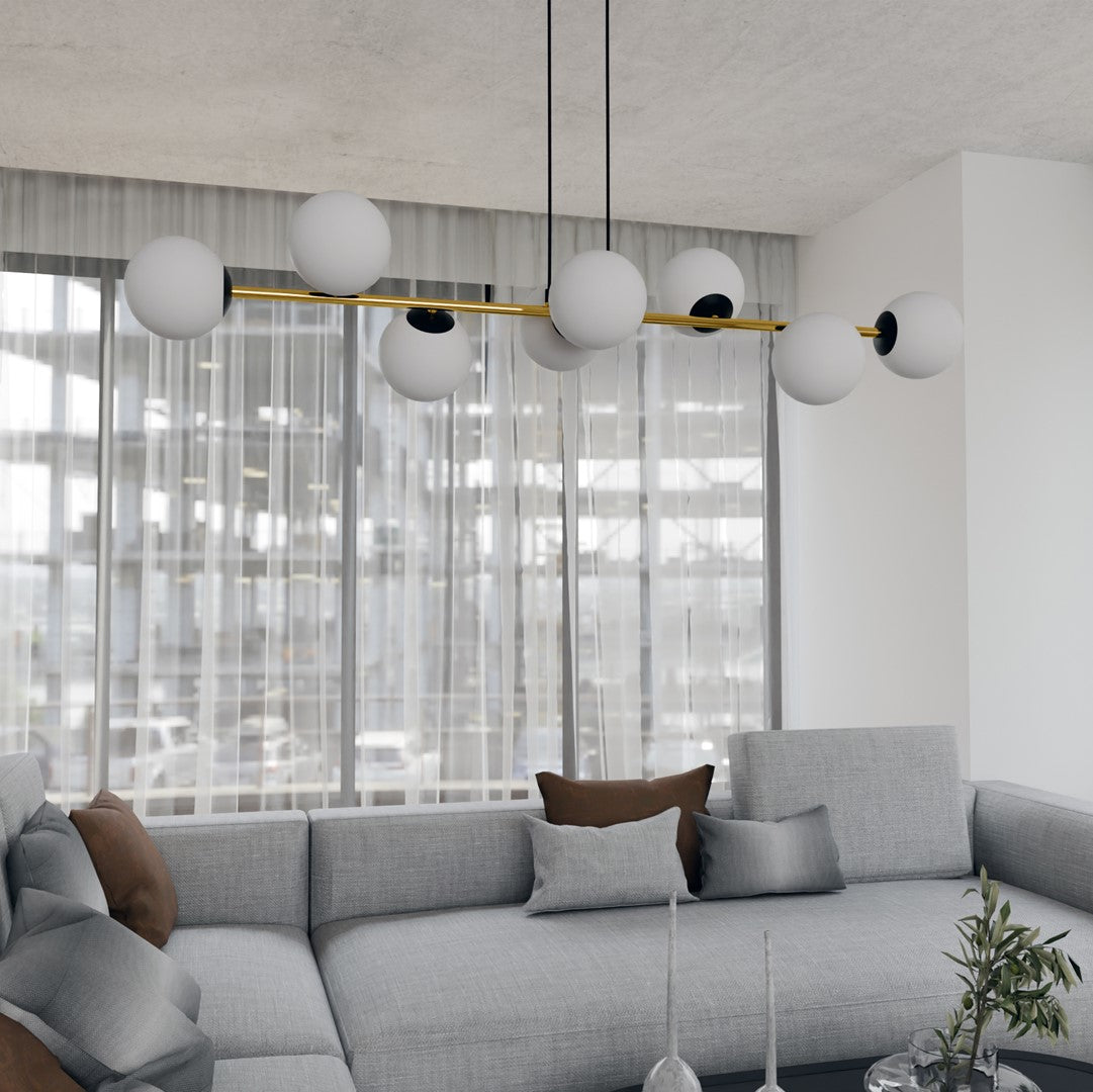 Mise en ambiance salon, suspension éteinte devant grandes fenêtres, canapé gris et coussins.
