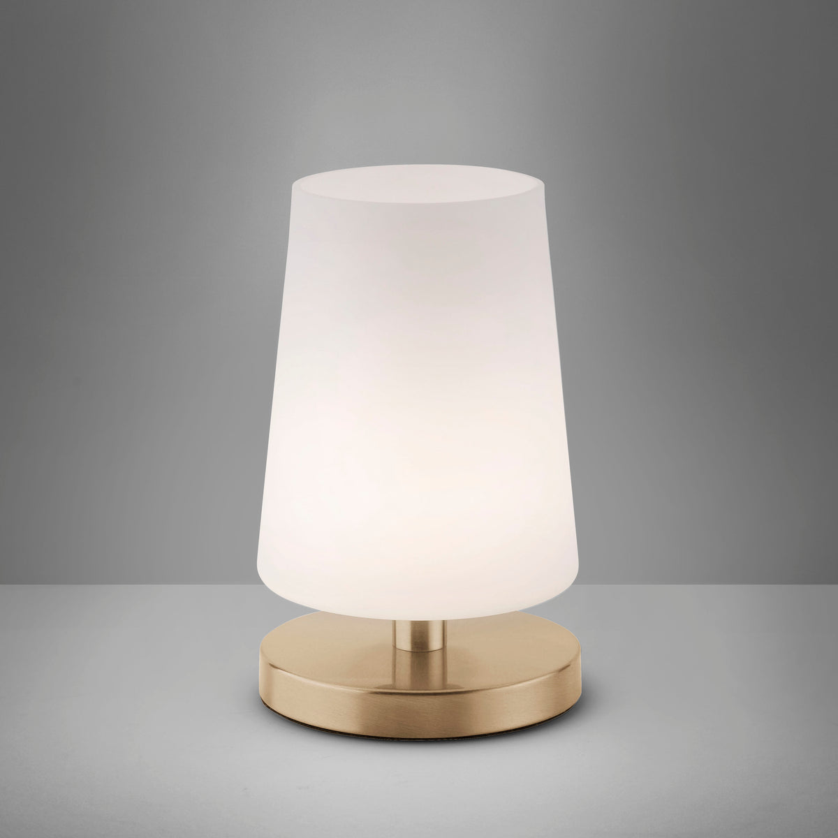Lampe allumée sur fond gris dégradé, lumière douce diffusée par le verre opale
