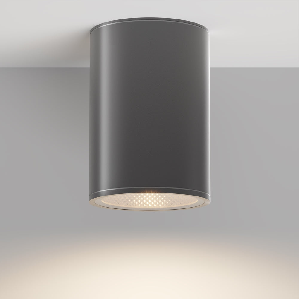 Vue de face du luminaire gris allumé sous plafond, halo lumineux diffus