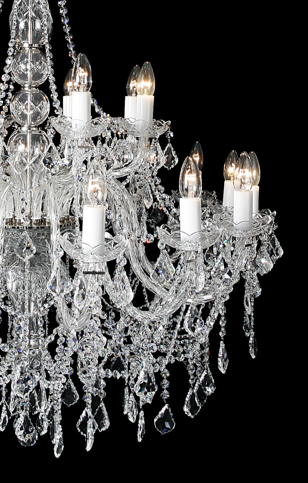 Gros plan des bras du lustre, bougies blanches et pendeloques de cristal