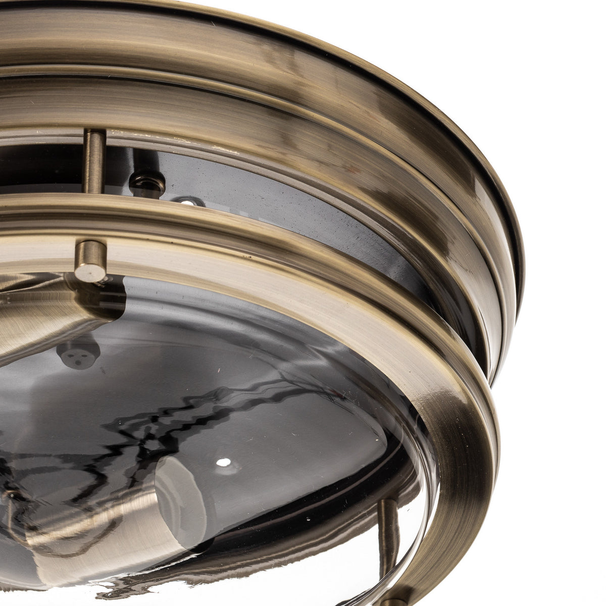Détail rapproché de la bague en laiton brossé et du verre transparent.