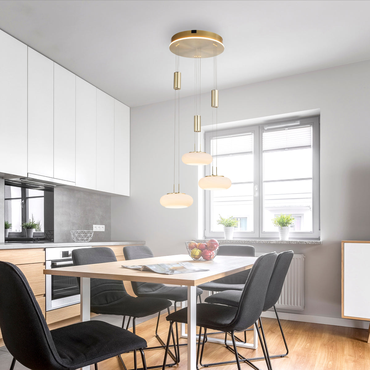 Mise en ambiance au-dessus d'une table de salle à manger, suspension allumée dans une cuisine moderne.