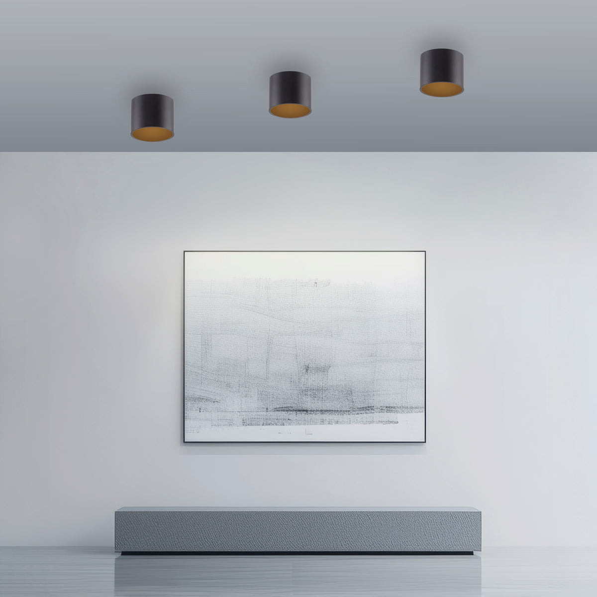 Mise en ambiance avec trois plafonniers noirs fixés au plafond au-dessus d'une toile.