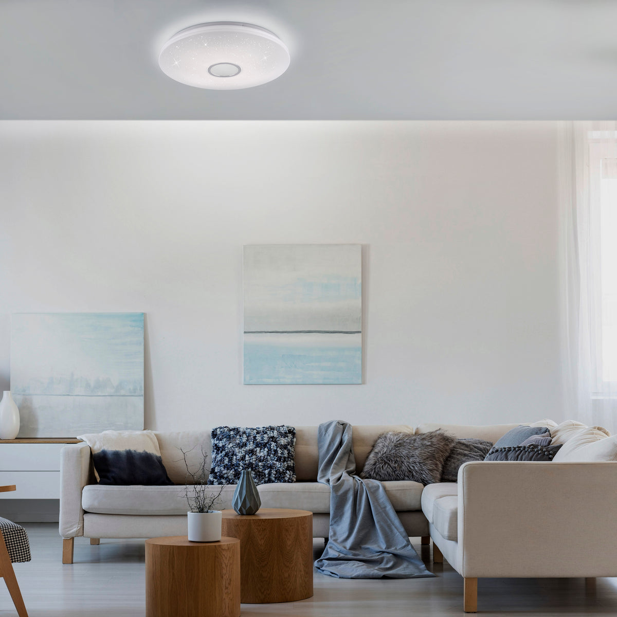 Plafonnier allumé au plafond d'un salon au canapé beige