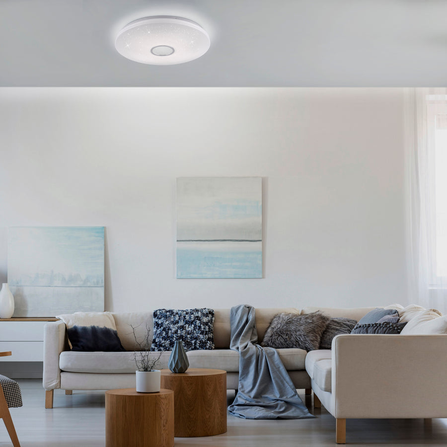 Plafonnier allumé au plafond d'un salon au canapé beige