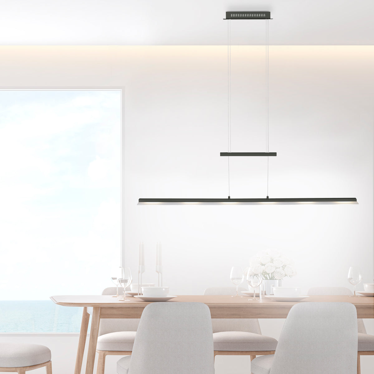Au-dessus d'une table à manger en bois clair, suspension linéaire allumée dans un intérieur épuré.
