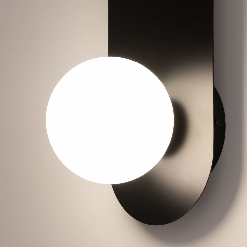 Gros plan sur le globe blanc et la finition noire mate de la plaque