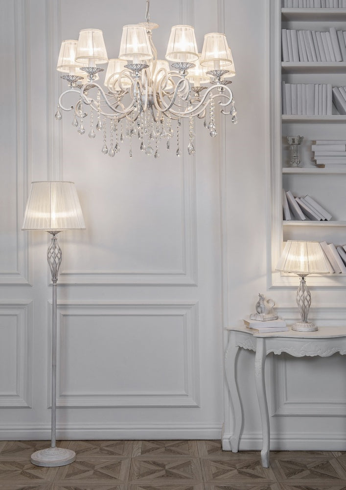 Mise en ambiance du lustre allumé dans un salon blanc avec bibliothèque