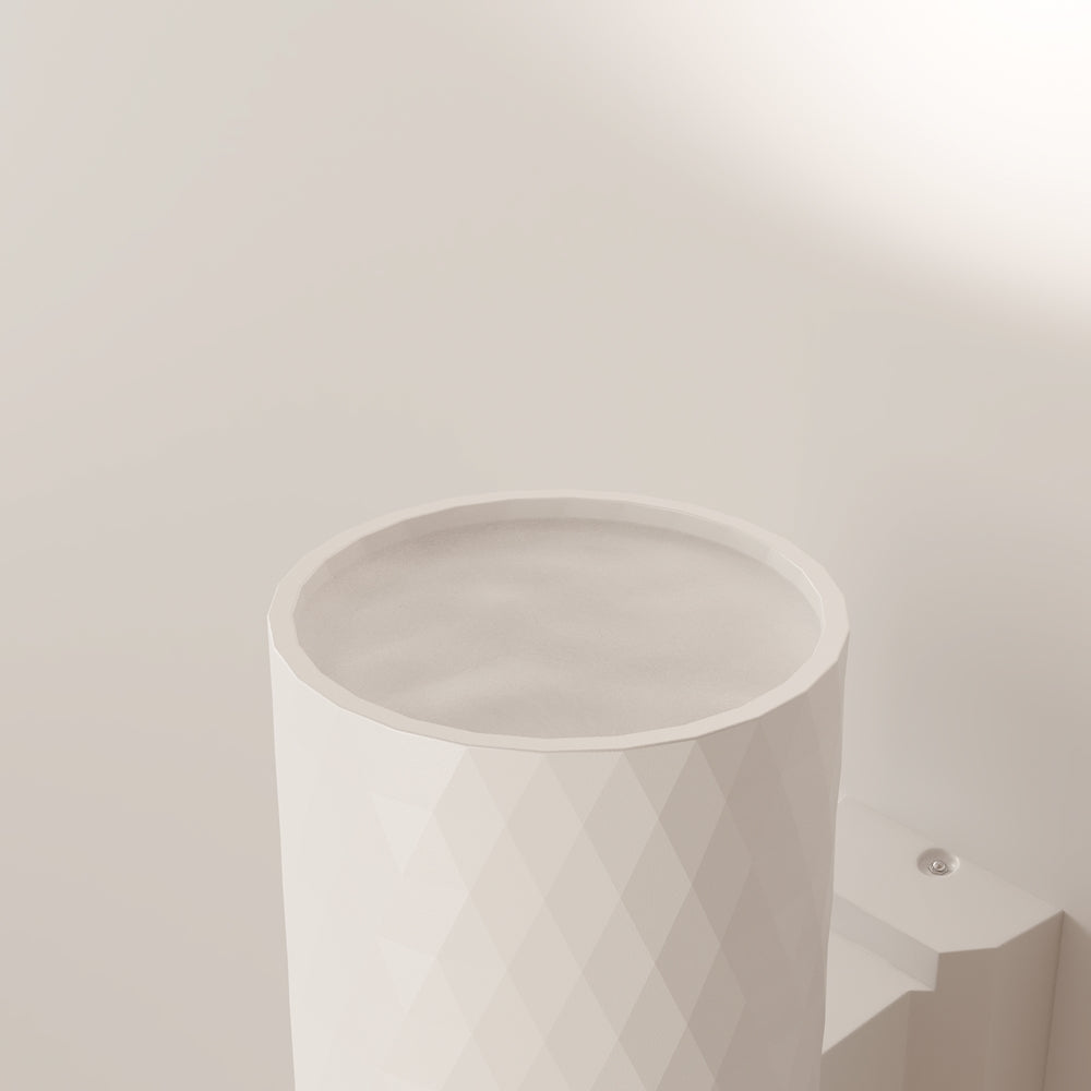 Gros plan sur l'ouverture supérieure du luminaire blanc et son support mural.