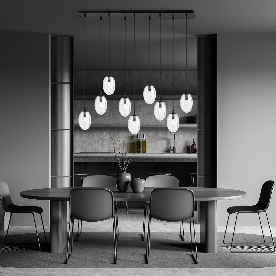 Suspension allumée au-dessus d'une table à manger grise dans un intérieur contemporain