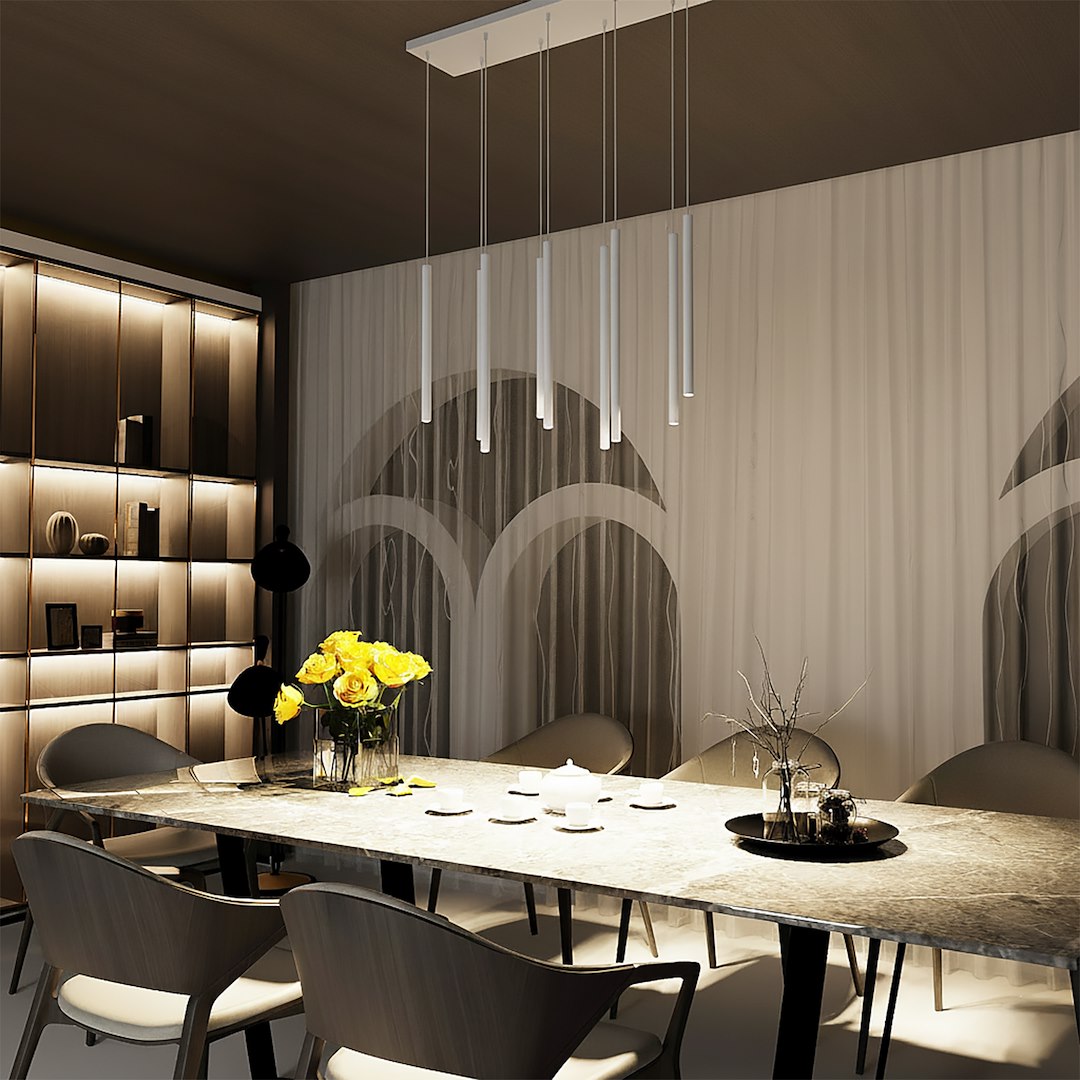 Ambiance de salle à manger éclairée, suspension blanche dominant la table dressée.