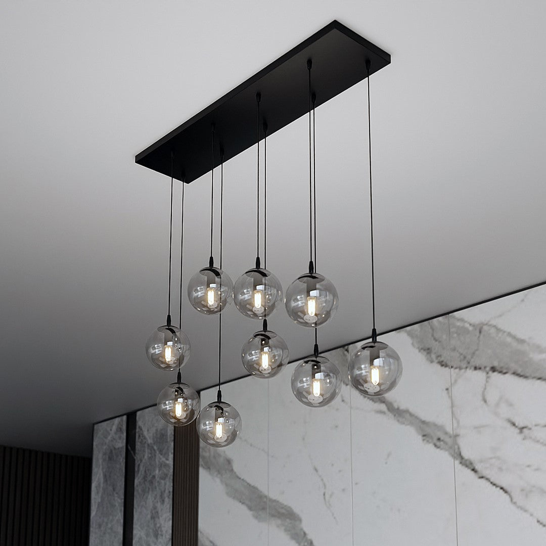 Détail du plateau noir fixé au plafond et des neuf globes en verre fumé.