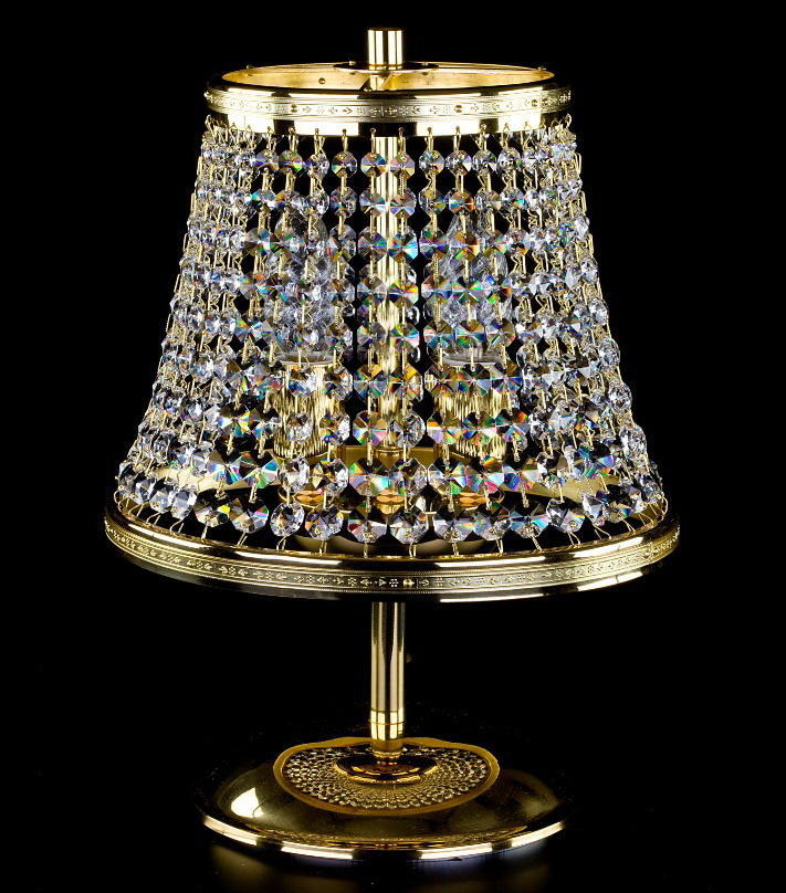 Version dorée de la lampe à poser, abat-jour en cristaux, vue de face sur fond noir.