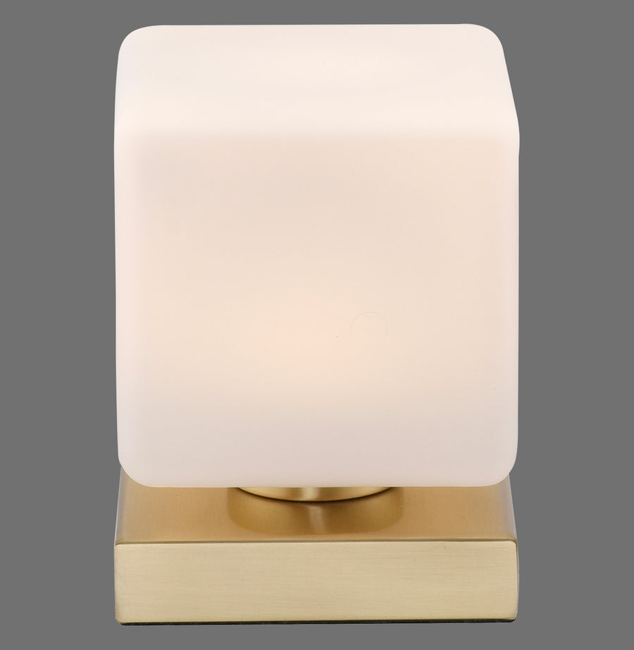 Vue de face de la lampe à poser, abat-jour carré en verre et base en laiton.
