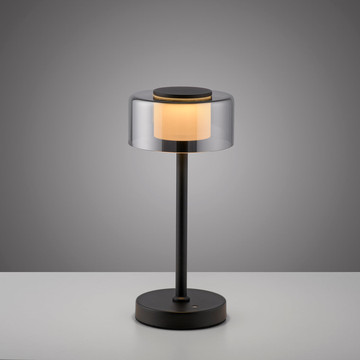 Produit centré de face sur fond gris dégradé, abat-jour transparent et socle rond