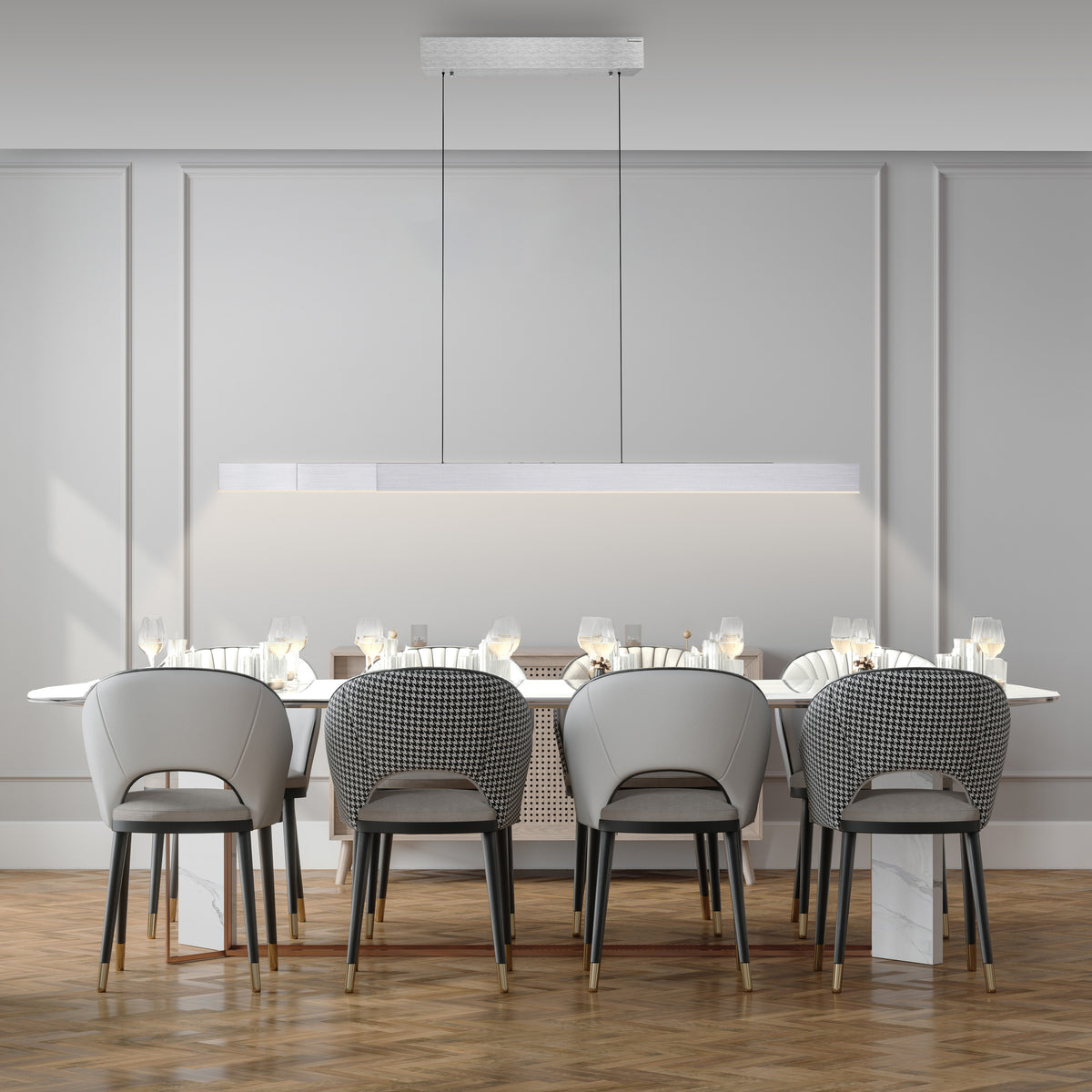 Mise en ambiance au-dessus d'une table, suspension linéaire allumée dans une salle à manger.