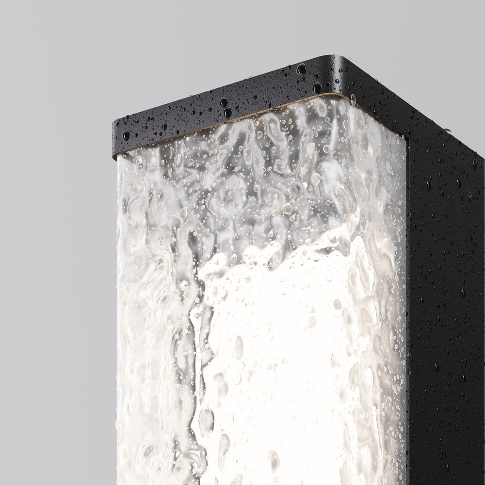 Détail du luminaire couvert de gouttes d'eau sur cadre noir et verre texturé