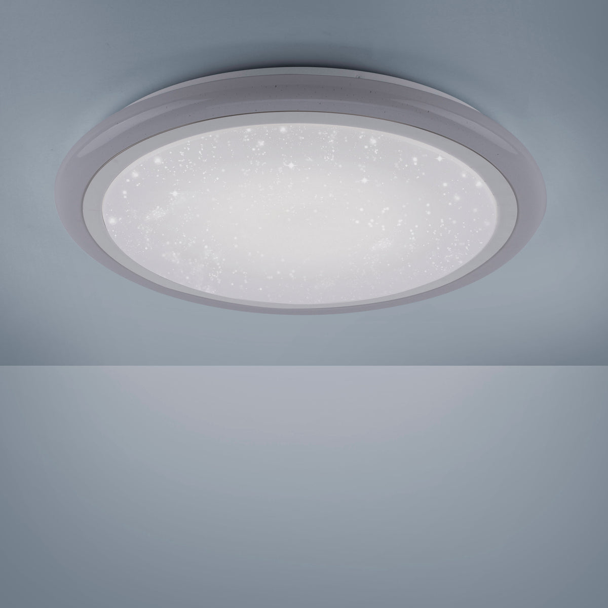 Plafonnier allumé fixé au plafond, diffusant lumière blanche et halo
