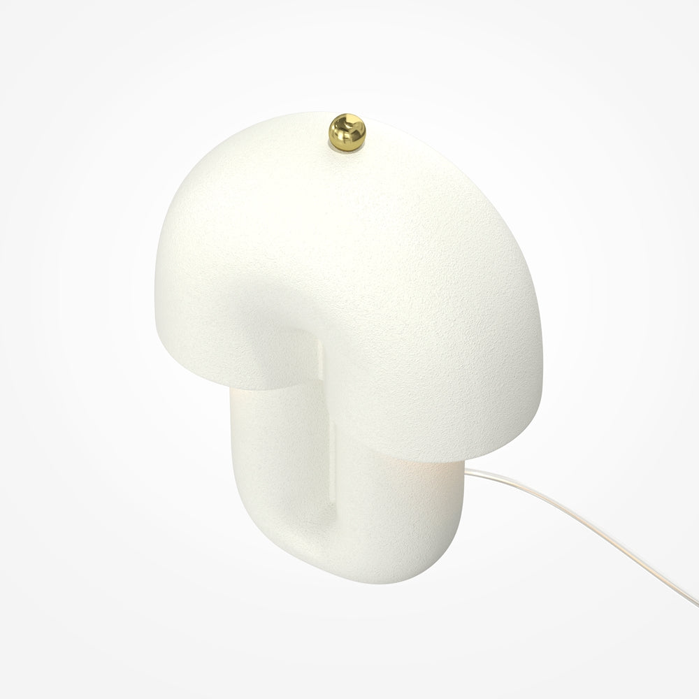Vue de trois quarts de la lampe blanche mate avec bouton doré sur le dessus.