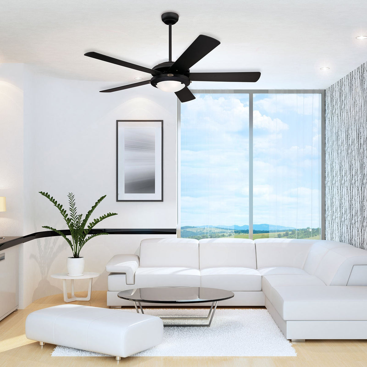 Ventilateur de plafond noir installé dans un salon blanc lumineux, au-dessus d’un canapé