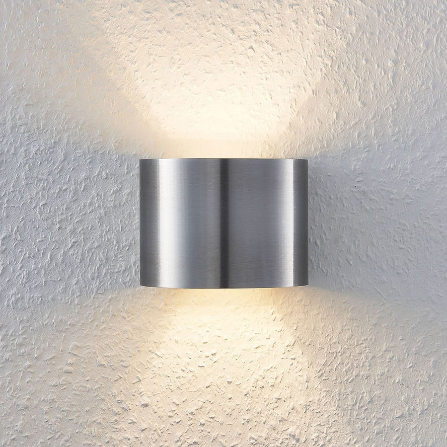 Applique murale en aluminium brossé allumée, diffusant une lumière chaude vers le haut et le bas.