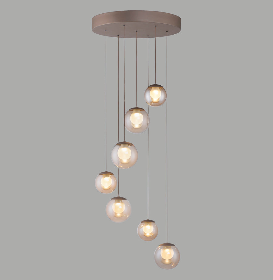 Vue de face de la suspension et ses huit globes en verre ambré allumés