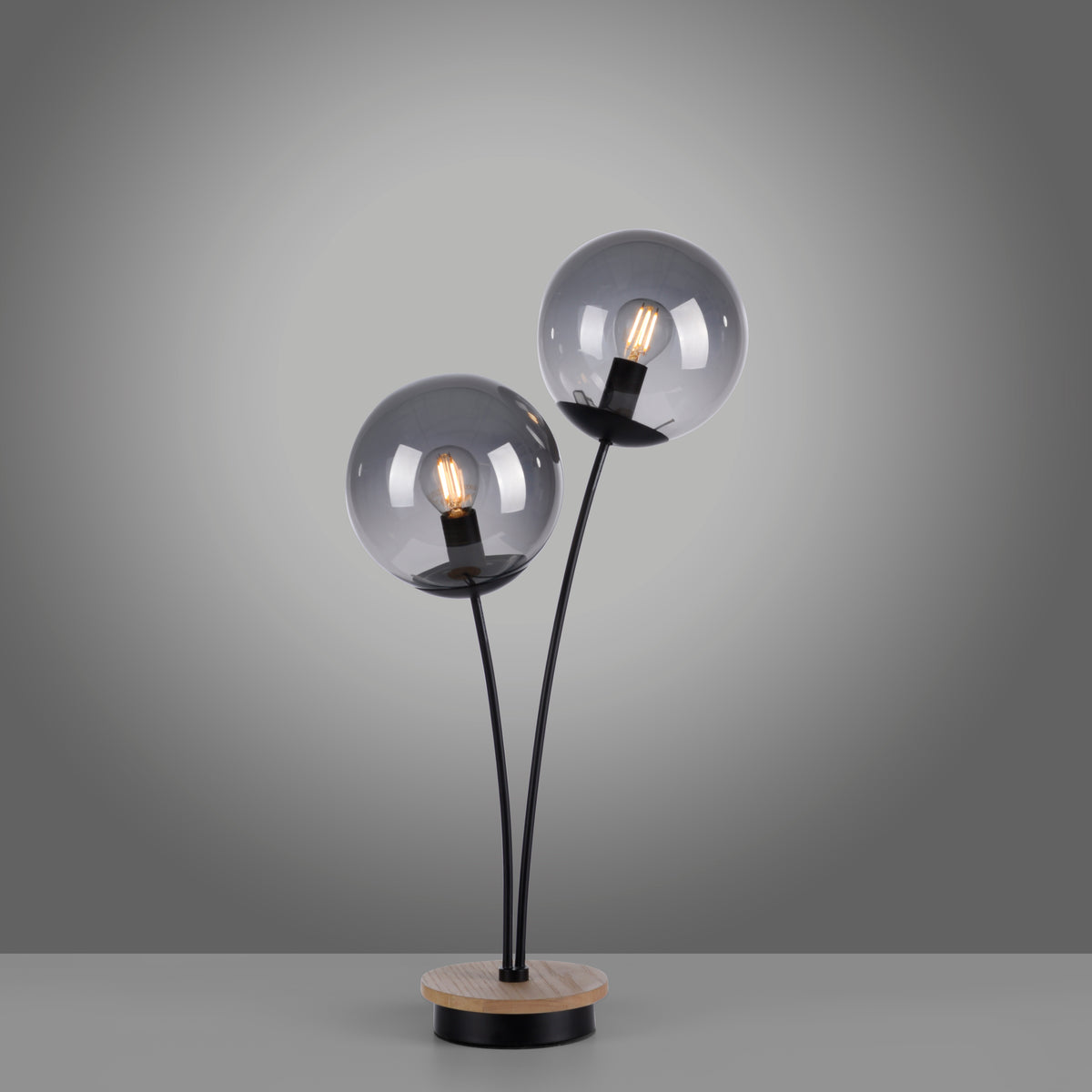 Détail des deux globes allumés avec filaments apparents, tiges noires et base en bois