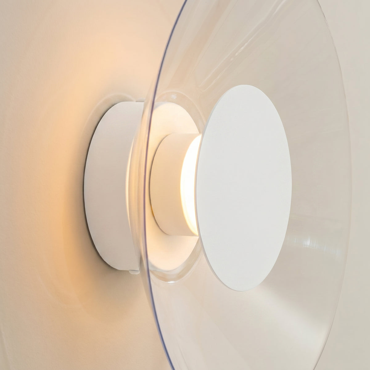 Détail de profil du socle blanc et du disque de verre bombé