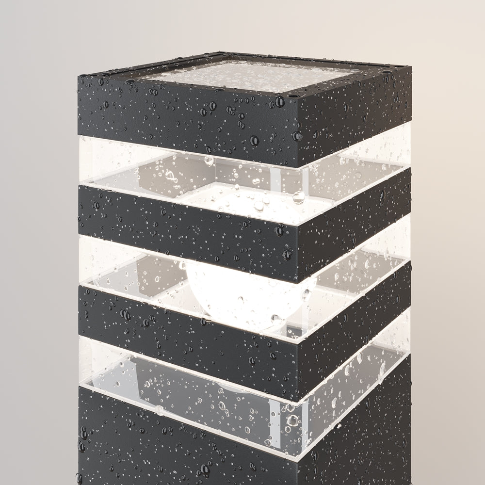 Détail du luminaire couvert de gouttes d'eau, résistance aux intempéries.