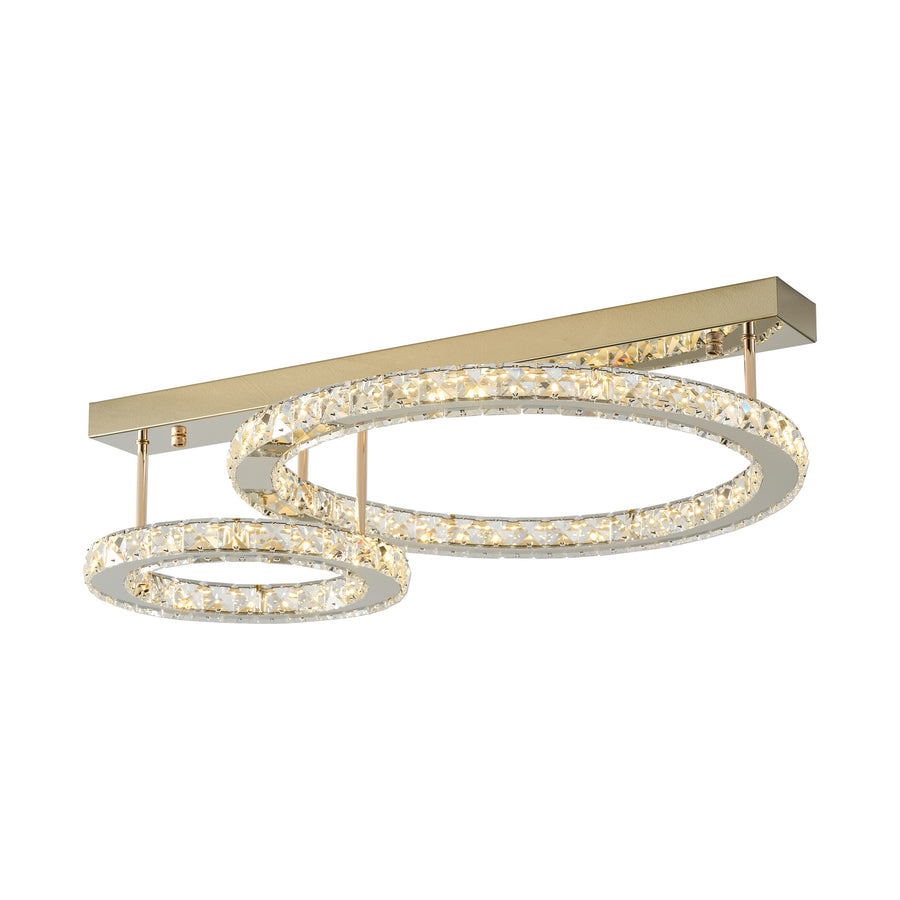 Luminaire de plafond doré allumé, deux anneaux cristal imbriqués, fond blanc.