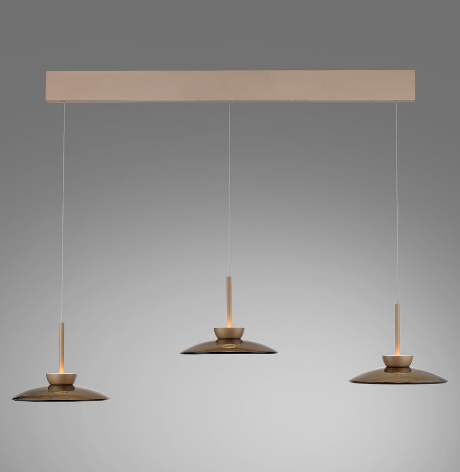 Vue de face du luminaire à trois suspensions en verre ambré sous un rail rectangulaire