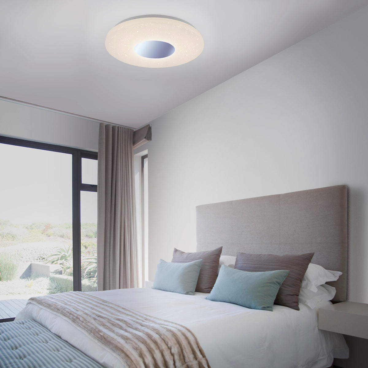 Mise en ambiance dans une chambre, plafonnier allumé au-dessus du lit