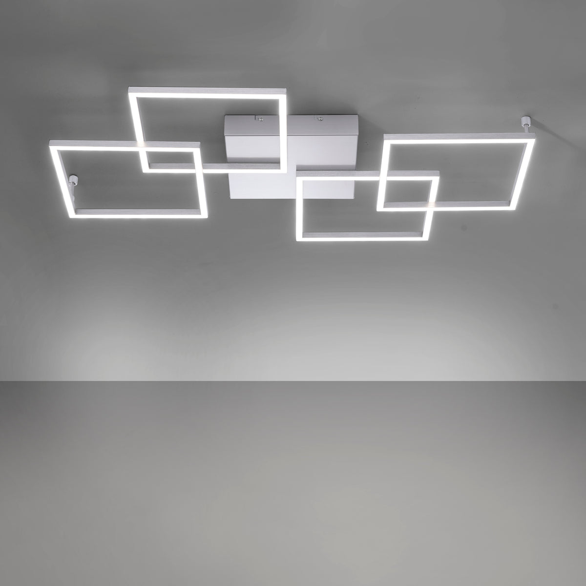 Détail de l'éclairage LED allumé, montrant le cadre rectangulaire lumineux fixé au plafond gris.