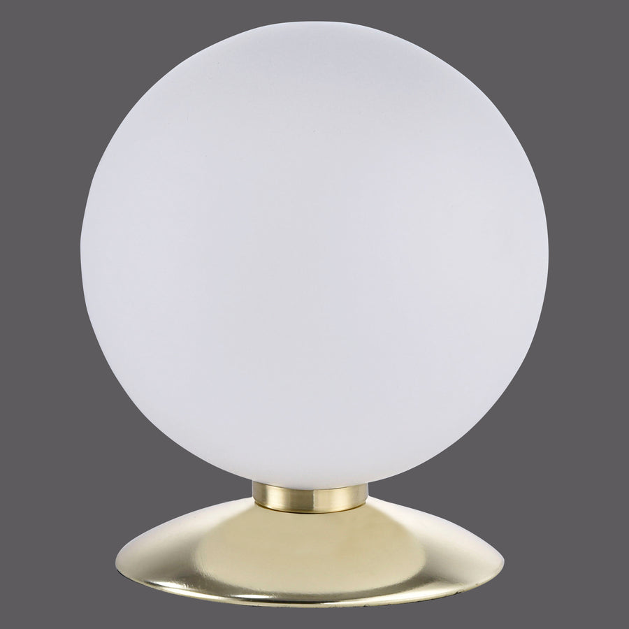 Lampe à poser sphérique, verre opalin blanc et base en laiton doré sur fond gris foncé.
