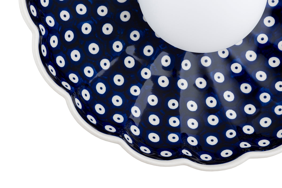 Détail de la finition, bord ondulé blanc et motif à pois perforés