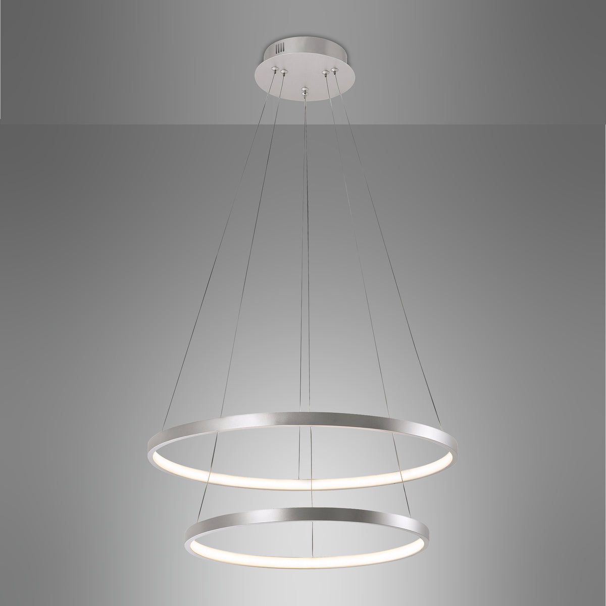 Vue rapprochée du luminaire suspendu sur fond gris dégradé, anneaux et câbles visibles