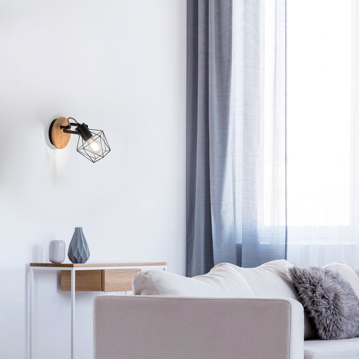 Mise en ambiance dans un salon blanc, applique allumée au-dessus d'une console en bois