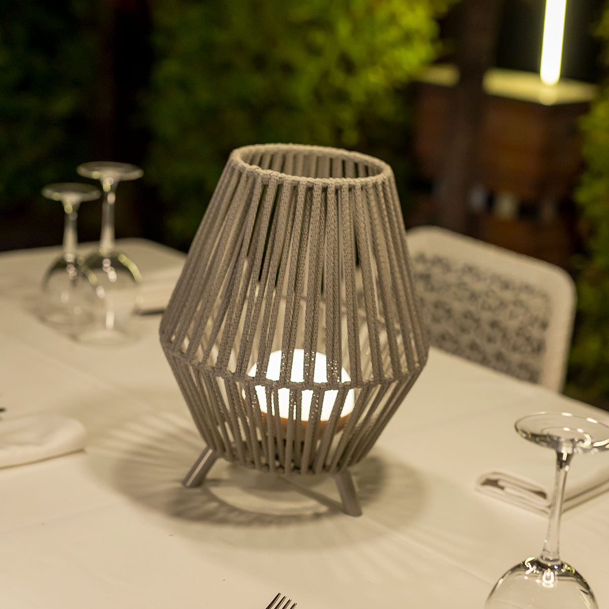 Vue rapprochée de la lampe posée sur nappe blanche, verres en arrière-plan