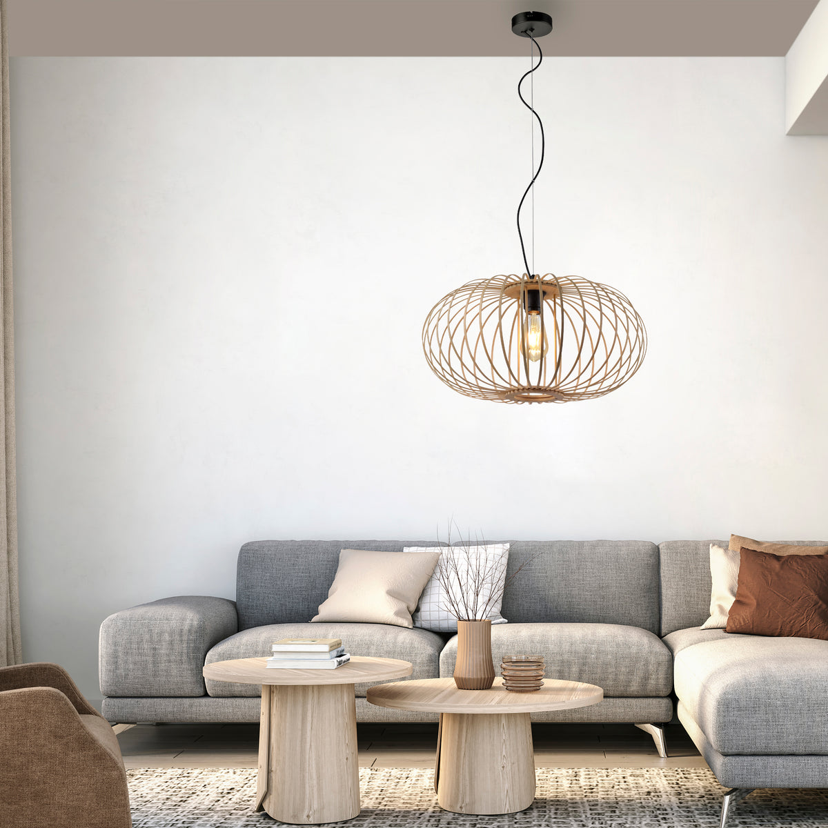 Mise en ambiance dans un salon moderne avec canapé gris et tables bois clair.