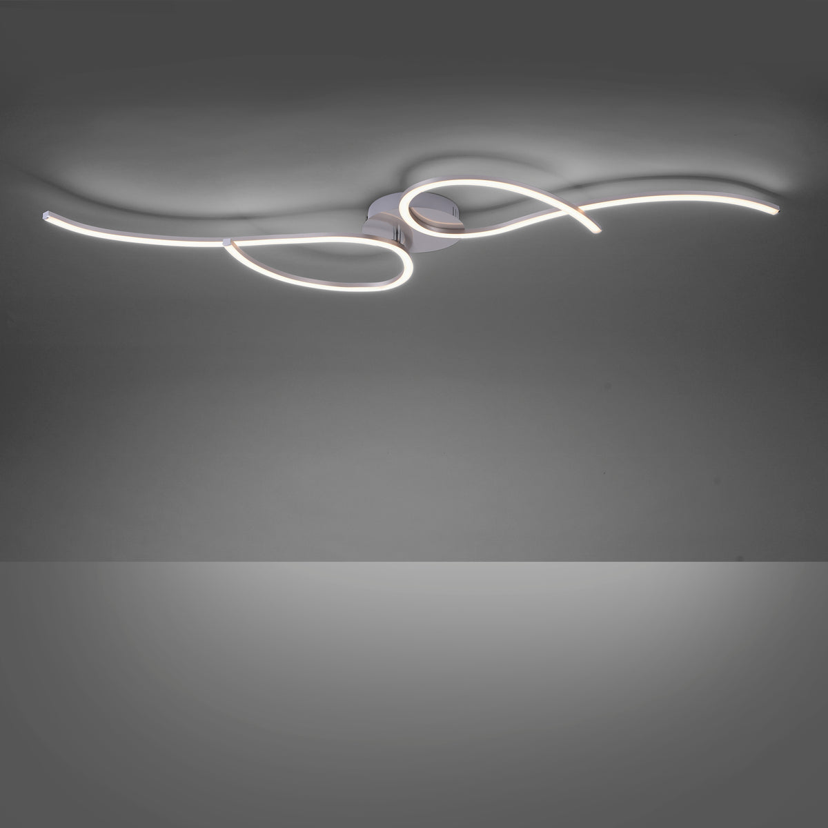 Luminaire allumé dans une pièce sombre, halos lumineux projetés au plafond par le ruban LED.
