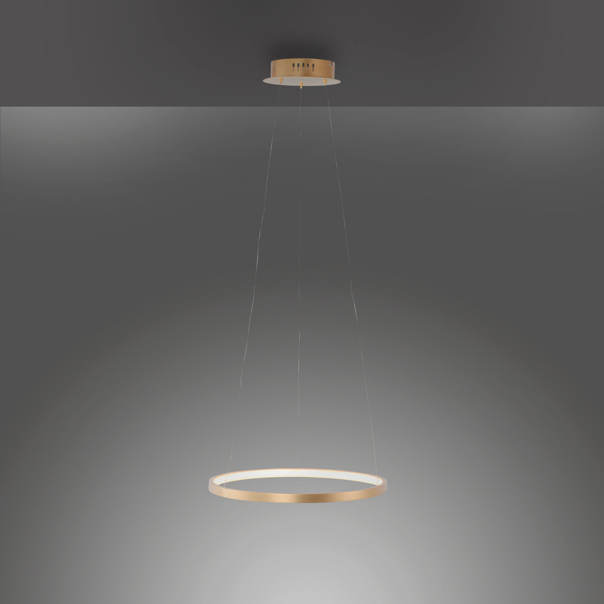 Luminaire suspendu allumé dans la pénombre diffusant un halo lumineux