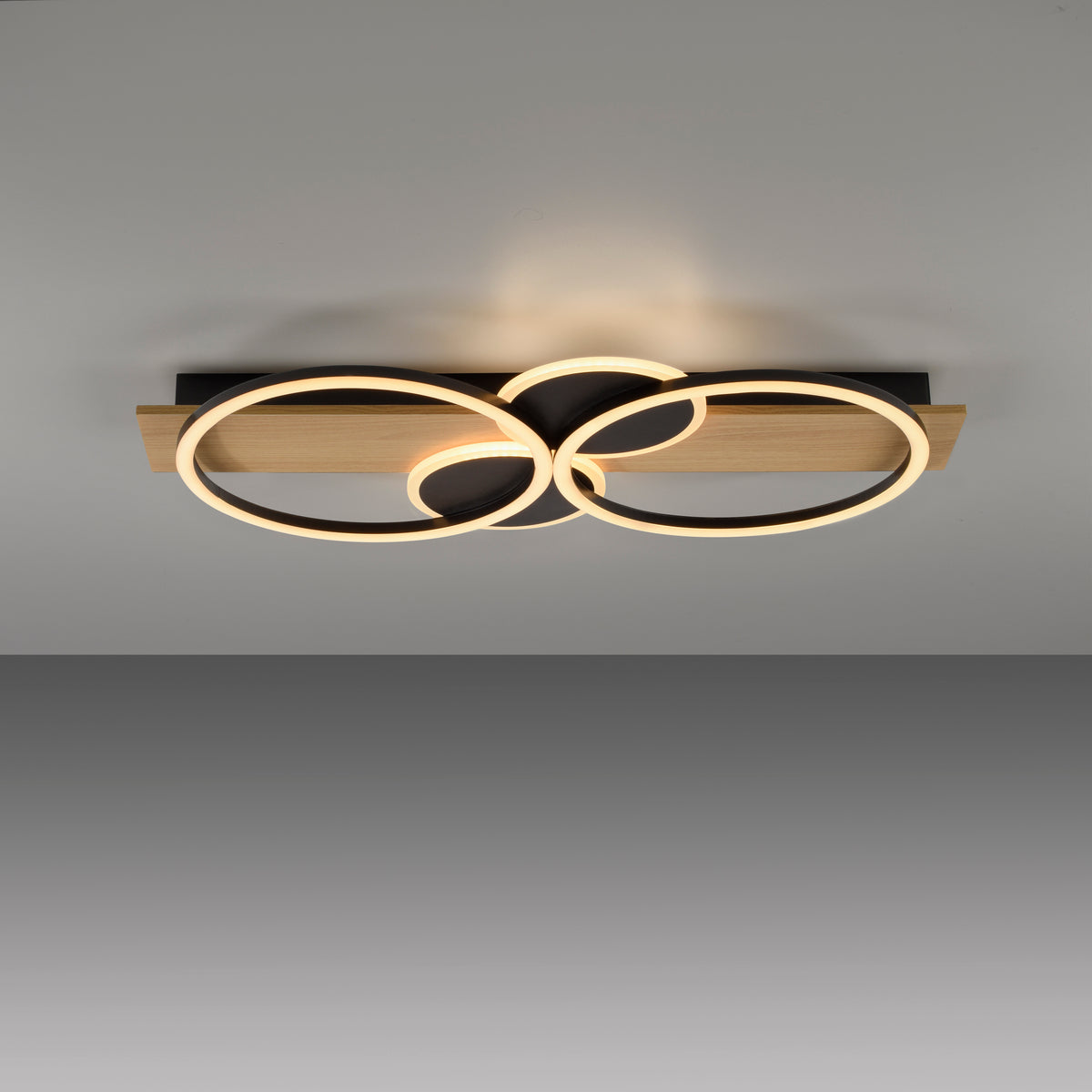 Vue du plafonnier fixé au plafond, diffusant une lumière chaude avec effet de halo.