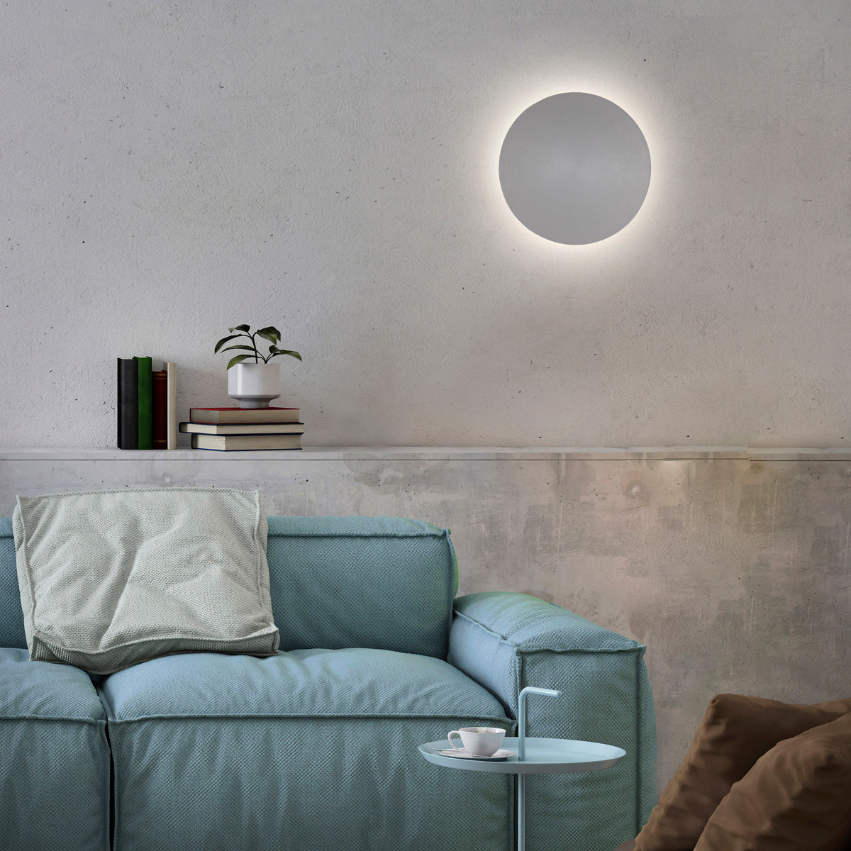Mise en ambiance au-dessus d'un canapé bleu, mur en béton