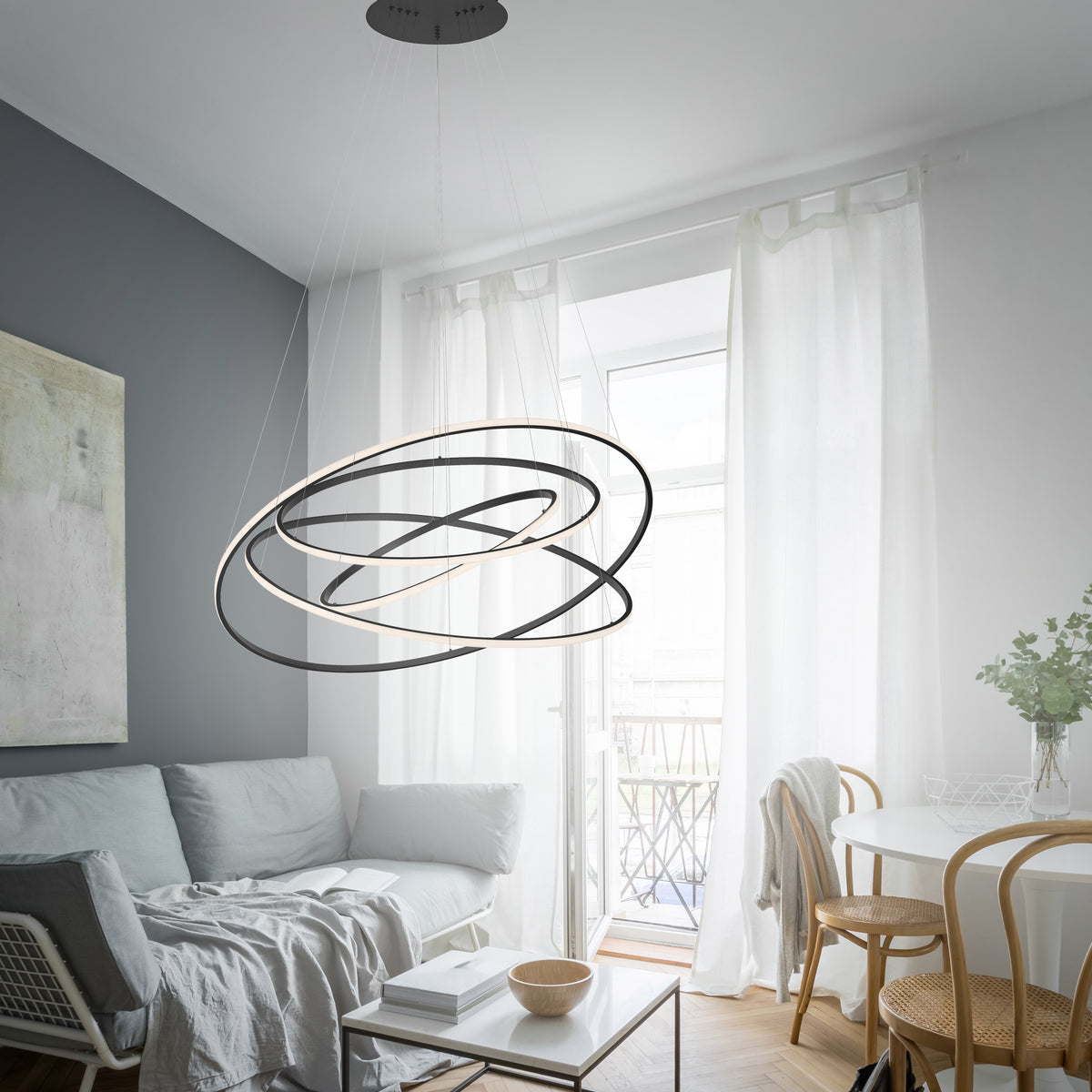 Mise en ambiance du luminaire suspendu au-dessus d'un salon contemporain aux tons gris clair.