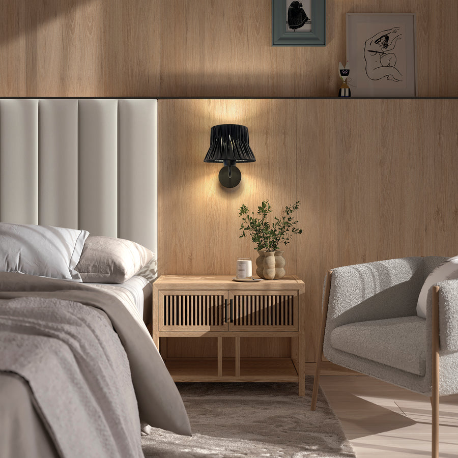 Ambiance chambre boisée avec applique noire allumée près du lit