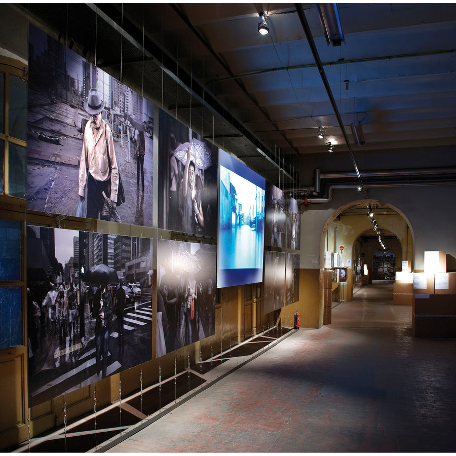 Spot orientable blanc éclairant des photographies dans une galerie sombre