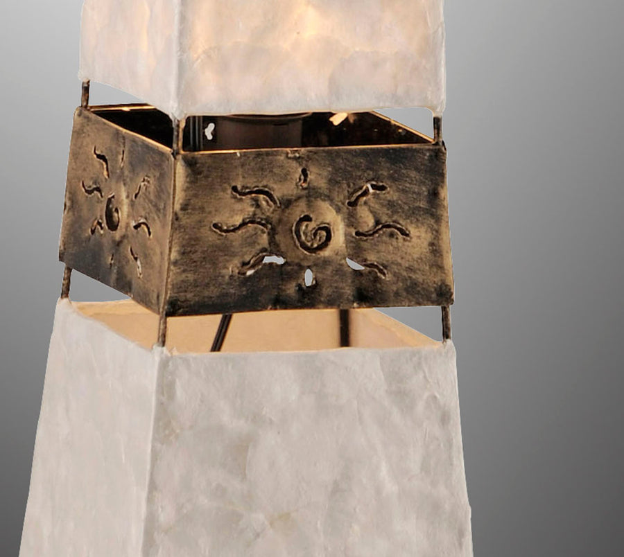 Détail rapproché d'une bague métallique ajourée à motif solaire stylisé