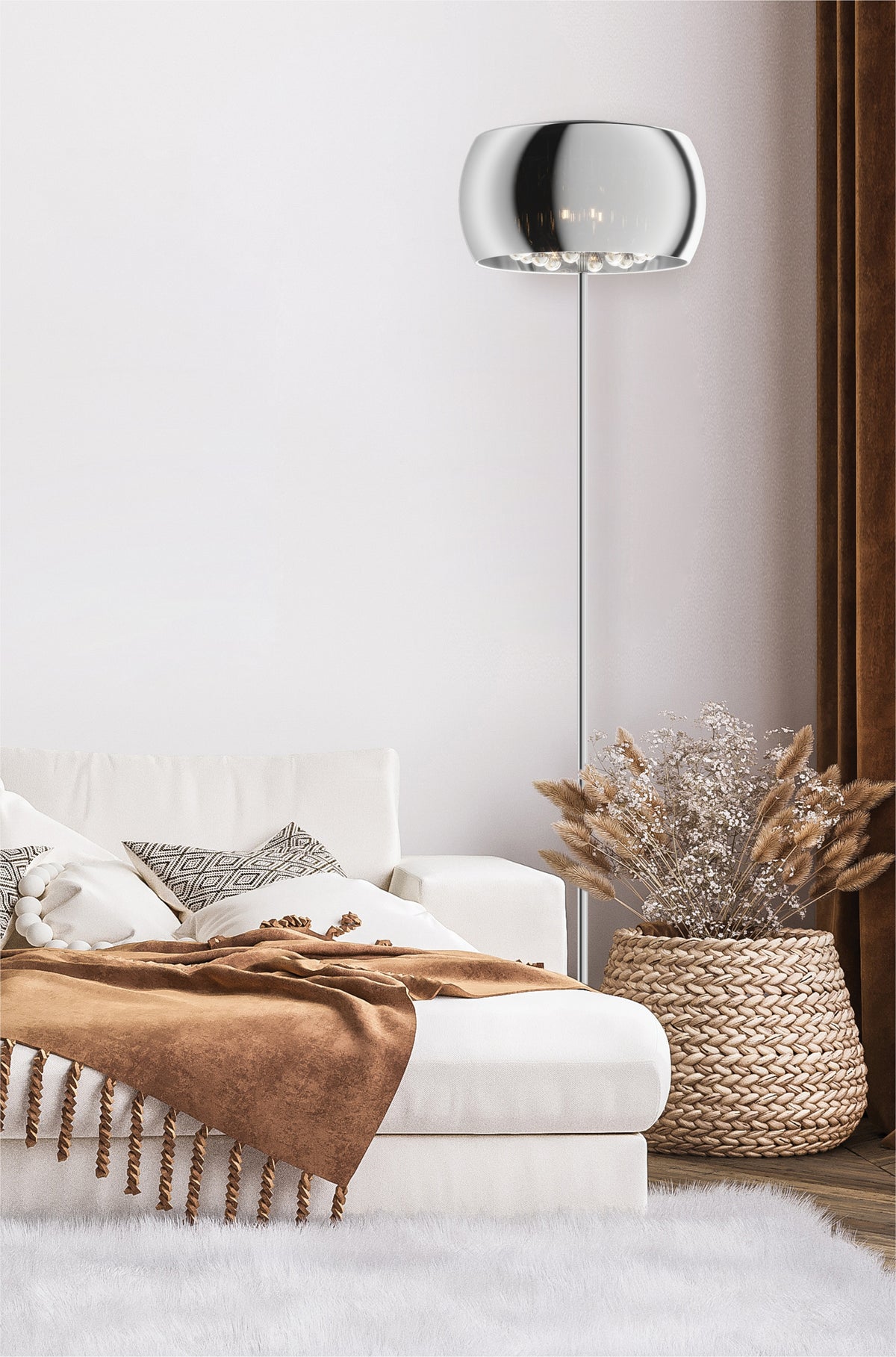 Lampadaire allumé dans une chambre, canapé blanc, plaid marron et panier tressé.