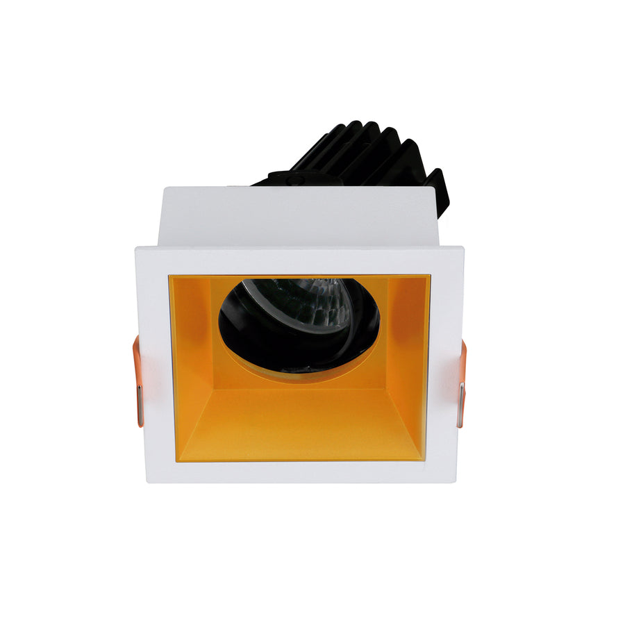Version à réflecteur intérieur doré, optique ronde noire et bord blanc carré.