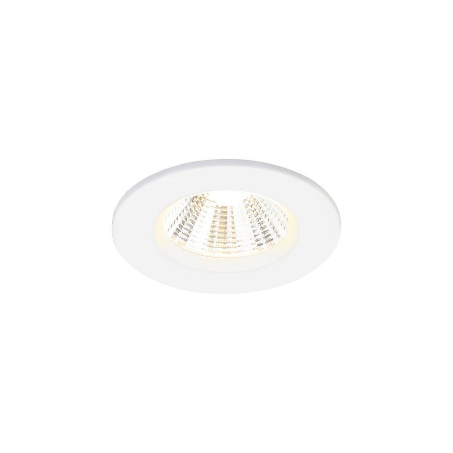 Vue rapprochée d'un spot encastré blanc incliné, lentille striée et ampoule LED allumée.